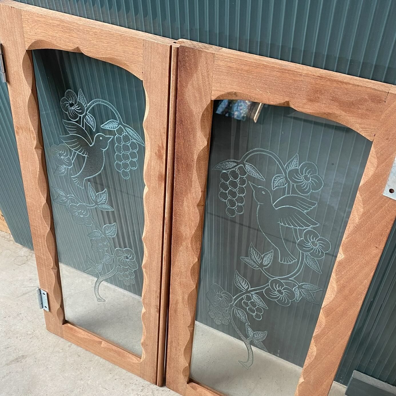 Arched wooden cabinet doors with etched bird and grapevine glass
